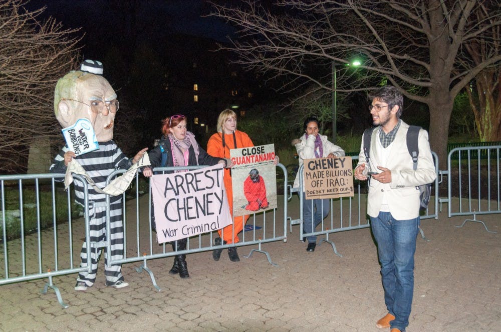 	Protesters chant as a passer-byer walks along the entry queue. 