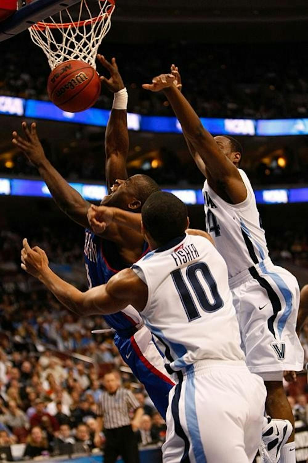 Senior guard Derrick Mercer fights through two opponents on his way to the hoop.