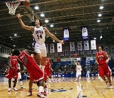 DESTRUCTIVE DUNK- Junior Brian Gilmore jumps up and attempts to score a basket as his opponent falls to the ground. The Eagles had a balanced weekend, losing their opening home game to Fairfield University on Thursday and defeating Stony Brook University 