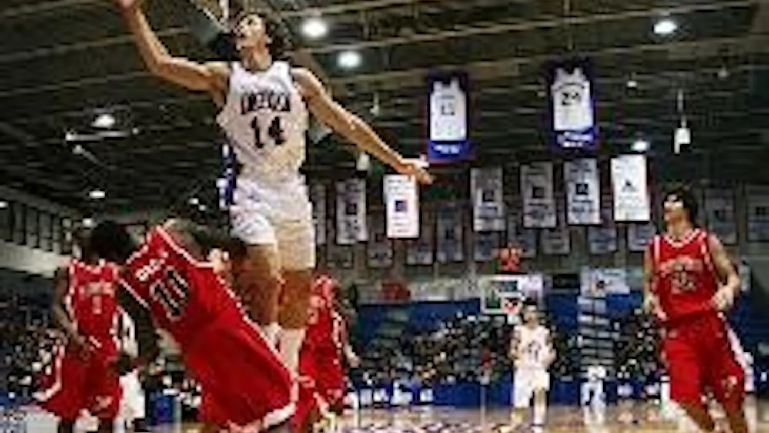 DESTRUCTIVE DUNK- Junior Brian Gilmore jumps up and attempts to score a basket as his opponent falls to the ground. The Eagles had a balanced weekend, losing their opening home game to Fairfield University on Thursday and defeating Stony Brook University