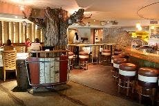 Luminous lanterns adorn the central tree that devides the dining room from the bar, creating a cozy atmosphere for patrons.