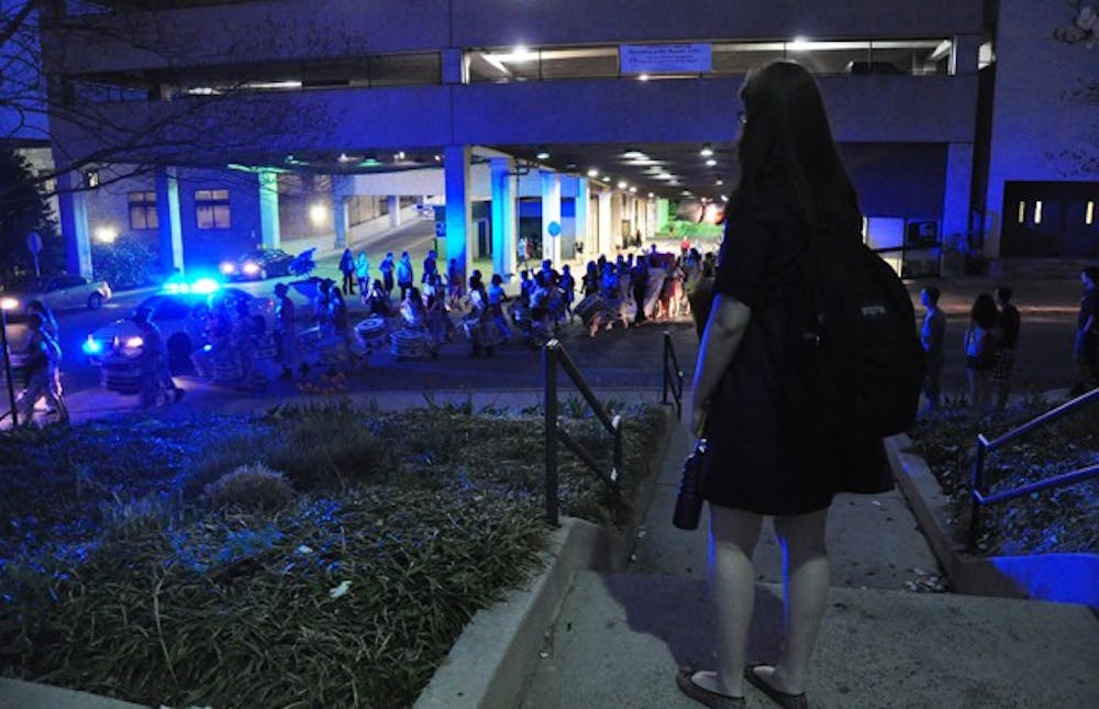 A student watches as demonstrators march towards South Side.