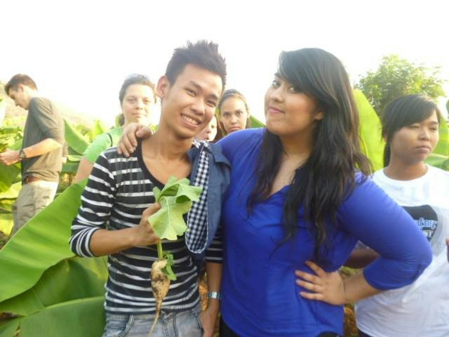 	Columnist Sarah Harvard (right) poses for a picture with a Burmese student (right) holding a radish.