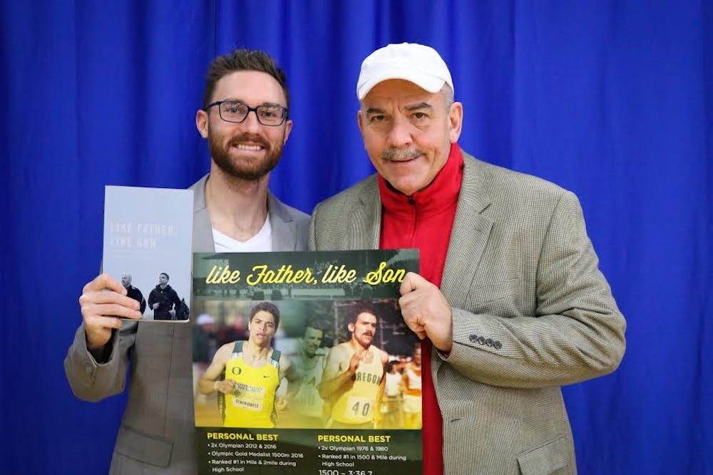 Assistant track coach&nbsp;Chris&nbsp;Kwiatkowski, left, and head coach&nbsp;Matthew Centrowitz, Sr. pose with Centrowitz's memoir "Like Father, Like Son," which was published on January&nbsp;19.