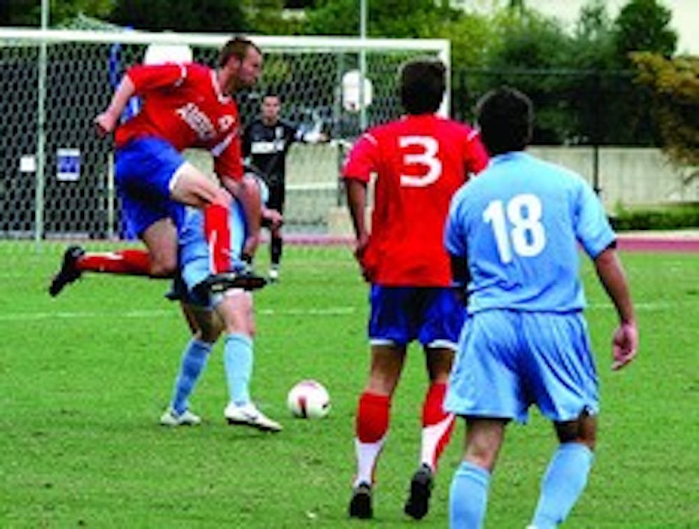 PLAYING FROM HIGH HEIGHTS- Cameron Petty watches as fellow Eagle Cooper Bryant does anything it takes to get his opponent away from the ball, even if it means jumping over him to prevent a goal. 