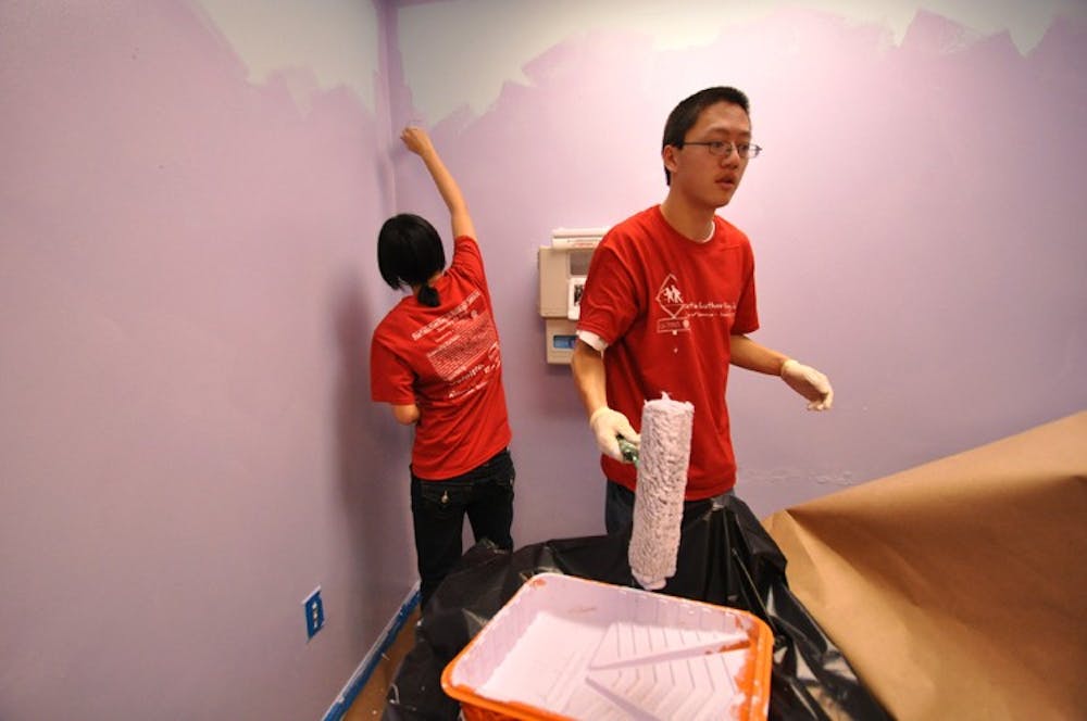Sophomores Sabrina Shee and Thomas Cheng paint the walls at the Family Health and Birth Center.
