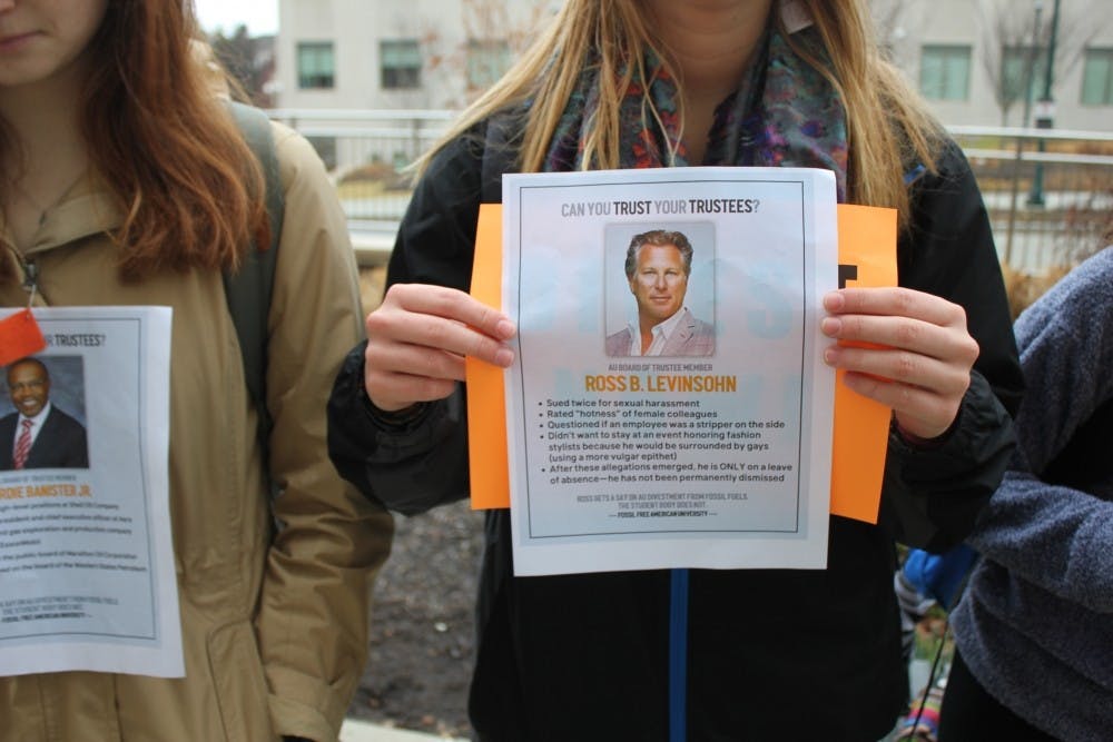 Protesters hold up signs critical of the Board of Trustees outside their winter meeting on Feb. 23.&nbsp;