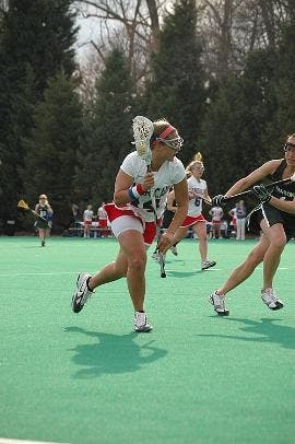 GOING FOR THE GOAL - Junior attacker Gina Ibello cradles the ball and runs down the field in an attempt to score a goal against her opponent. The team tallied another loss to their record Saturday, falling to Stony Brook.