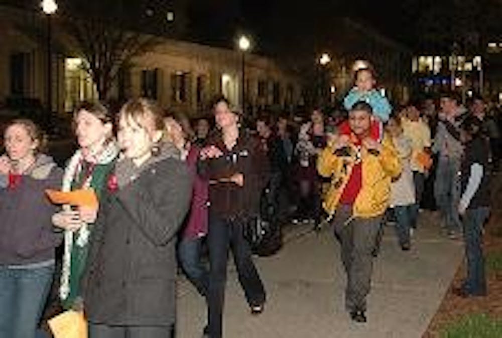 RAISING AWARENESS - AU students march past the Kogod School of Business during Take Back the Night Tuesday evening. The event, which also included time for people to give testimonials in Kay Spiritual Life Center, was held to raise awareness of domestic v