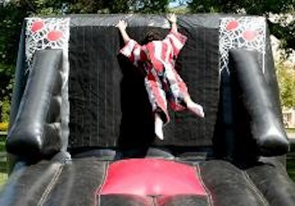 A student climbs a velcro wall set up on the quad to celebrate Artemas Ward Week. Other activities featured at the event included rock climbing and fortunetelling.