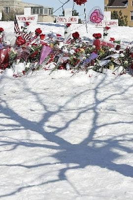 HONORING THE DEAD - Flowers, notes and stuffed animals adorn a row of crosses Saturday at a memorial for the students killed on the Northern Illinois University campus Thursday in DeKalb, Ill.