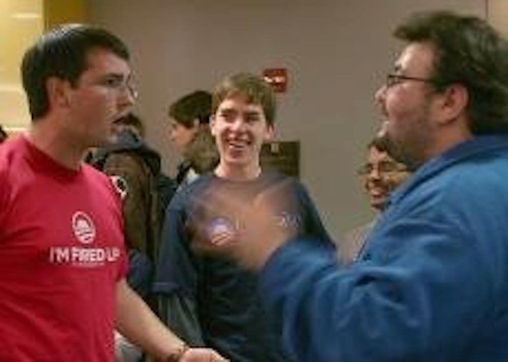 TALKING POLITICS - Aaron Luce (left) and Steve Dalton (right) get into a heated argument during the AU College Democrats' mock caucus Tuesday night. Illinois Sen. Barack Obama won the support of 26 students out of a group of 60 participants.