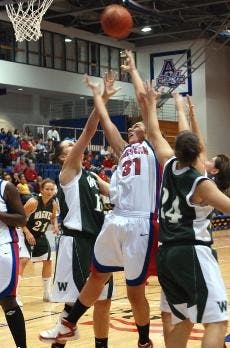 GRABBIN' FOR REBOUNDS - Junior Sahar Nusselbeh jumps in between her two opponents in an attempt to make the rebound as teammate Ohemaa Nyanin waits for the pass. AU evened out its record to 3-3 overall. 