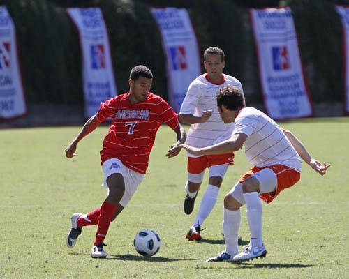 Dribbling around â€” Junior forward Jack Scott tries to work around a Syracuse Orange defender in the Eagles 2-1 victory.