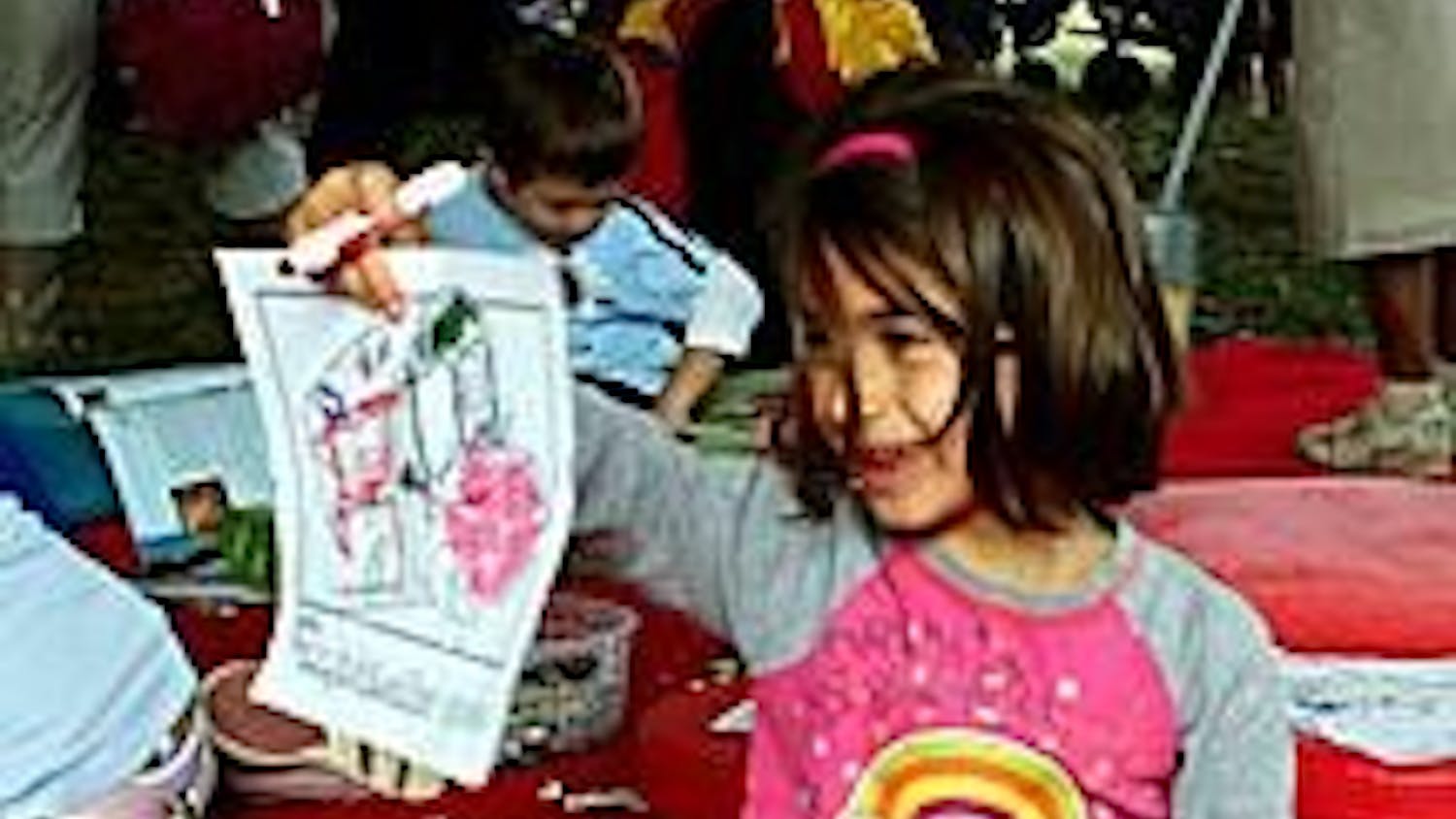 Nina McGranahan, age 5, colors a picture of the Magic Schoolbus, part of a children's exhibit. 