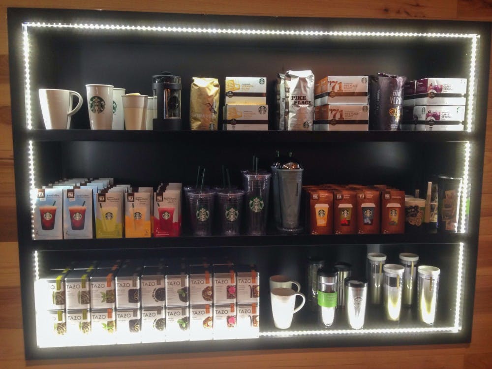 	Three shelves of Starbucks products light up the store as customers enter.