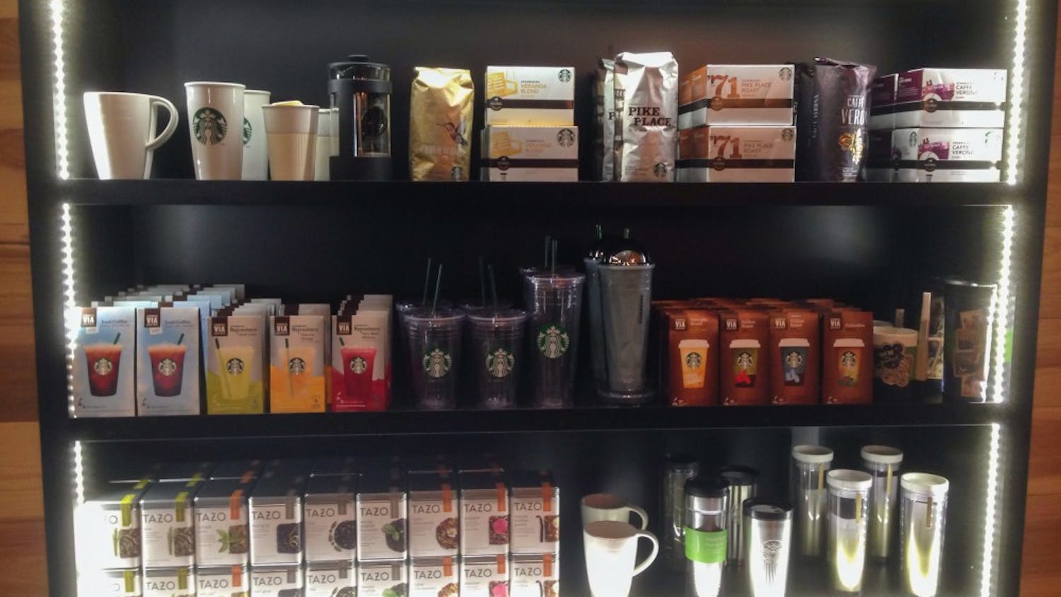 	Three shelves of Starbucks products light up the store as customers enter.