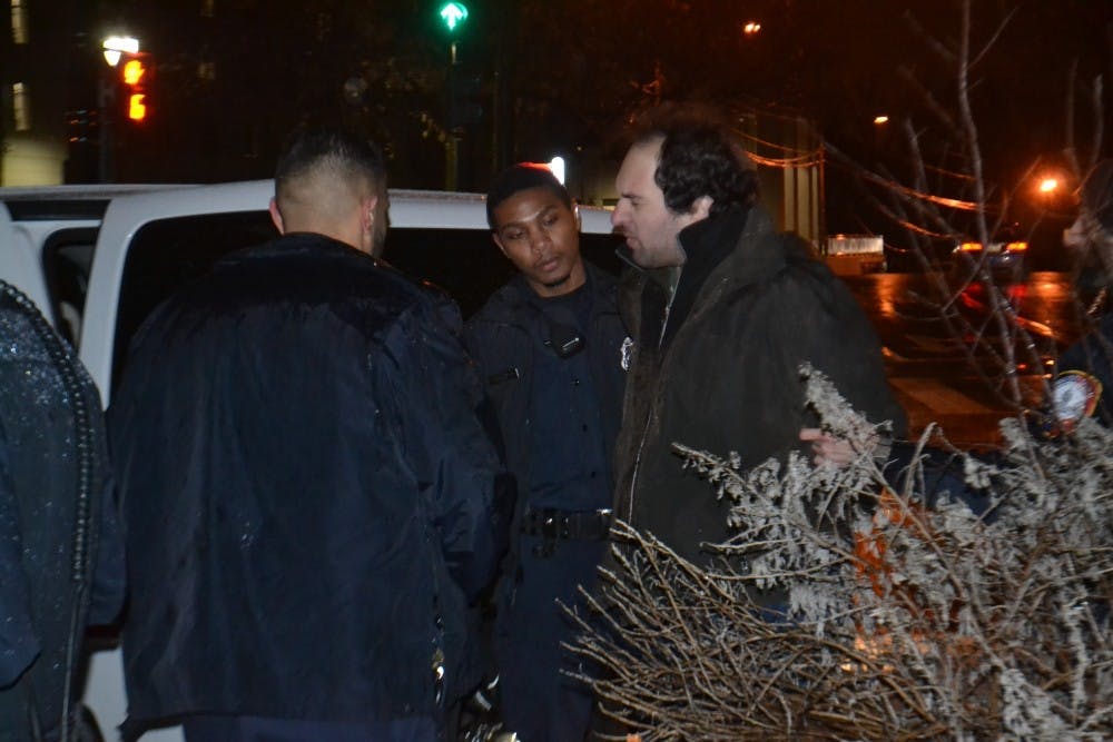 American University Police officers arrest graduate student Benjamin Brumer outside the School of International Service building Tuesday night.