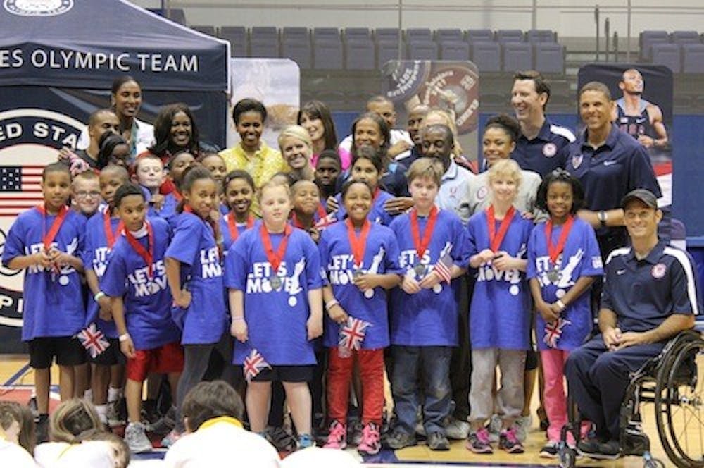 First Ladies Michelle Obama and Samantha Cameron pose with a group of elementary school students during a visit to AU.