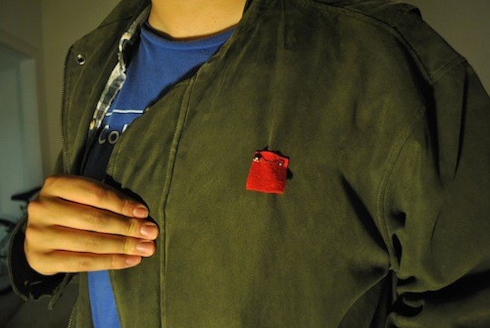 CAUS member Jack Kiraly wears a red felt square, modeled after squares worn by Québécois students worn during protest against tution hikes in Canada.