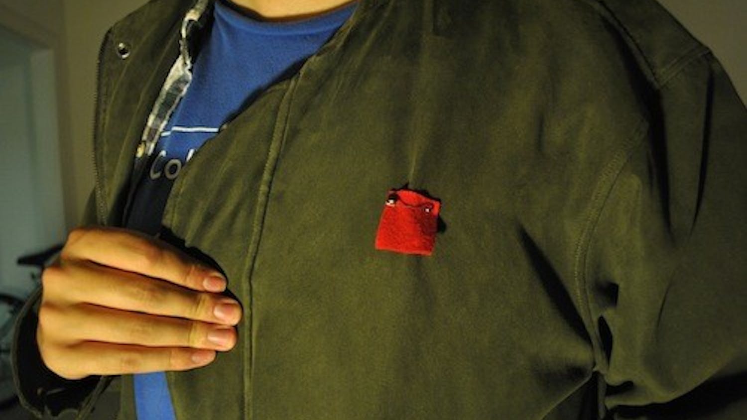 CAUS member Jack Kiraly wears a red felt square, modeled after squares worn by Québécois students worn during protest against tution hikes in Canada.