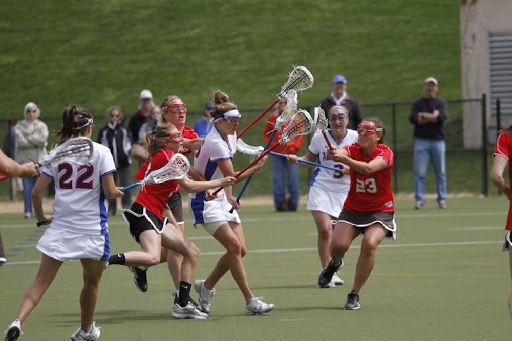 struggle for possessionâ€” An AU lacrosse player attempts to navigate through the defense in a game from earlier this season against Davidson College. The team fell to the College of the Holy Cross on Saturday in their quest for a Patriot League tournament berth. They finished the season with a record of 6-10. 