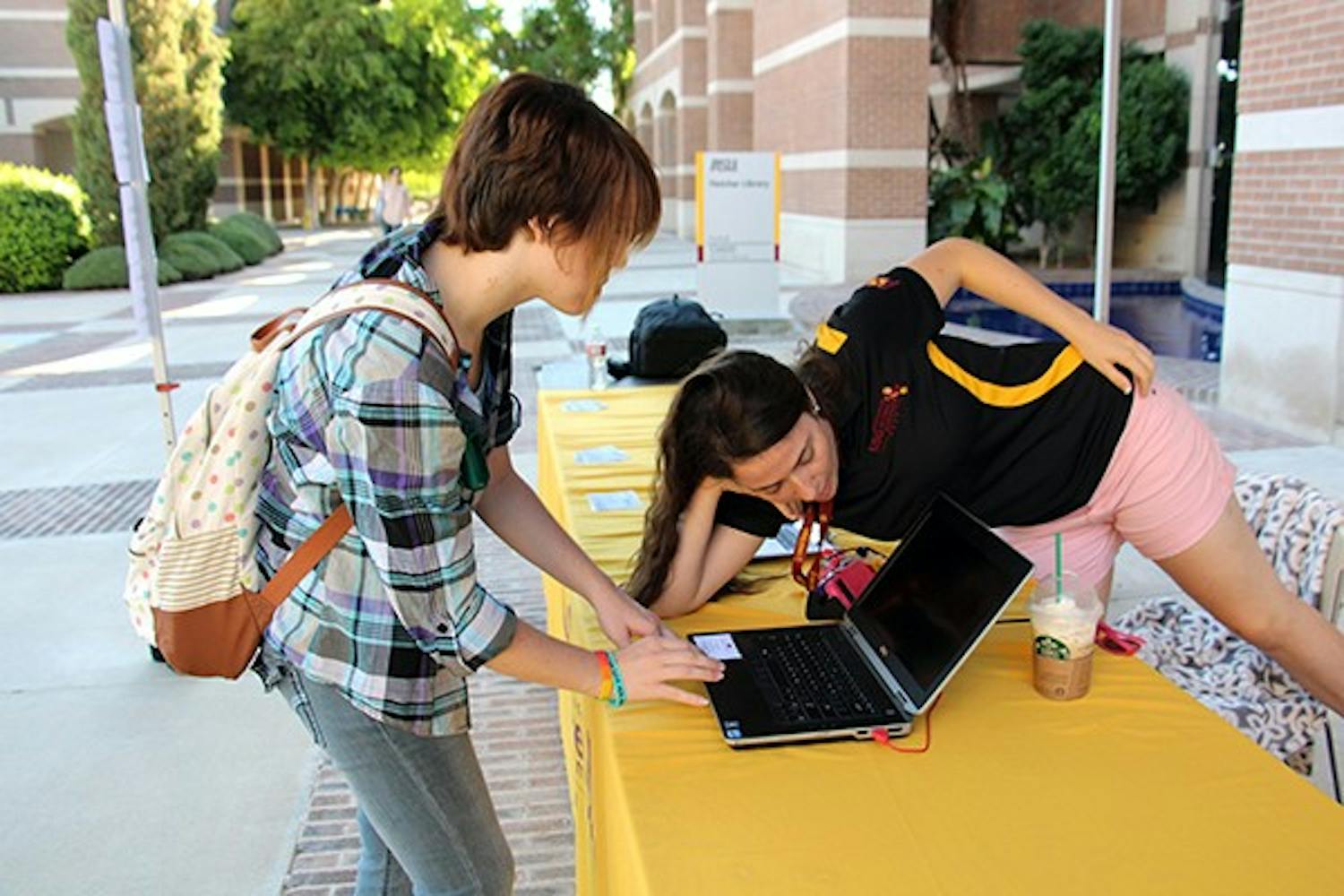 USG students representative Rachael Tashbook, right, helps analytics and global logistics junior Amanda Benjamin register to vote. The deadline for registration is Oct. 6, so the USG is encouraging students to sign up soon. (Photo by Tynin Fries)