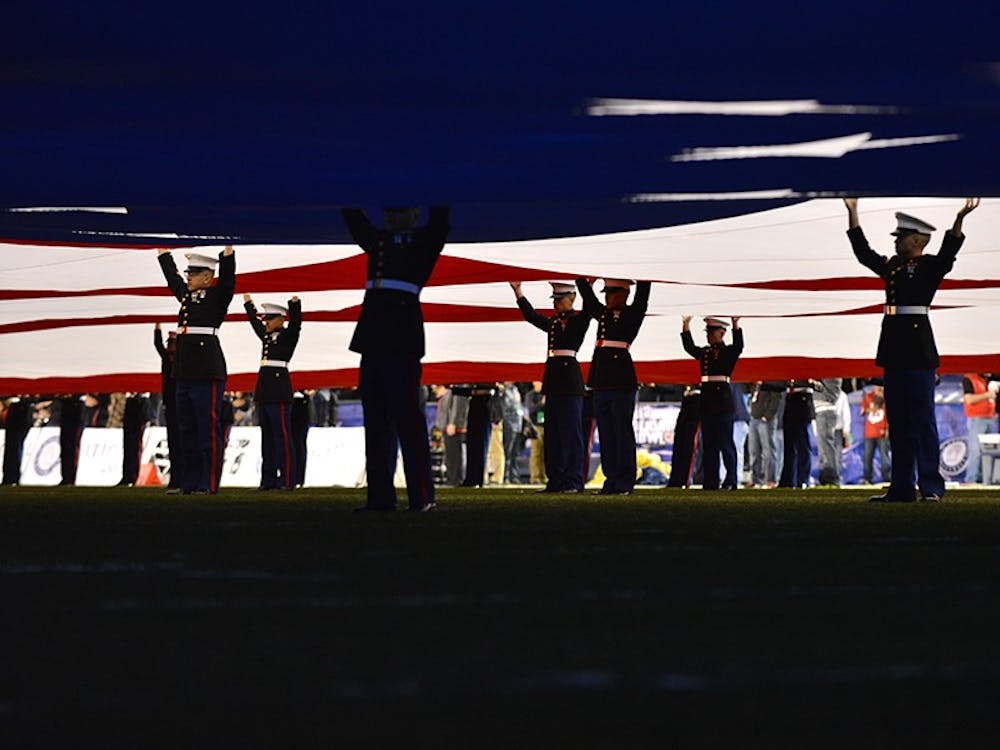 U.S. Marines hold up the U.S. flag on the field at Qualcomm Stadium.