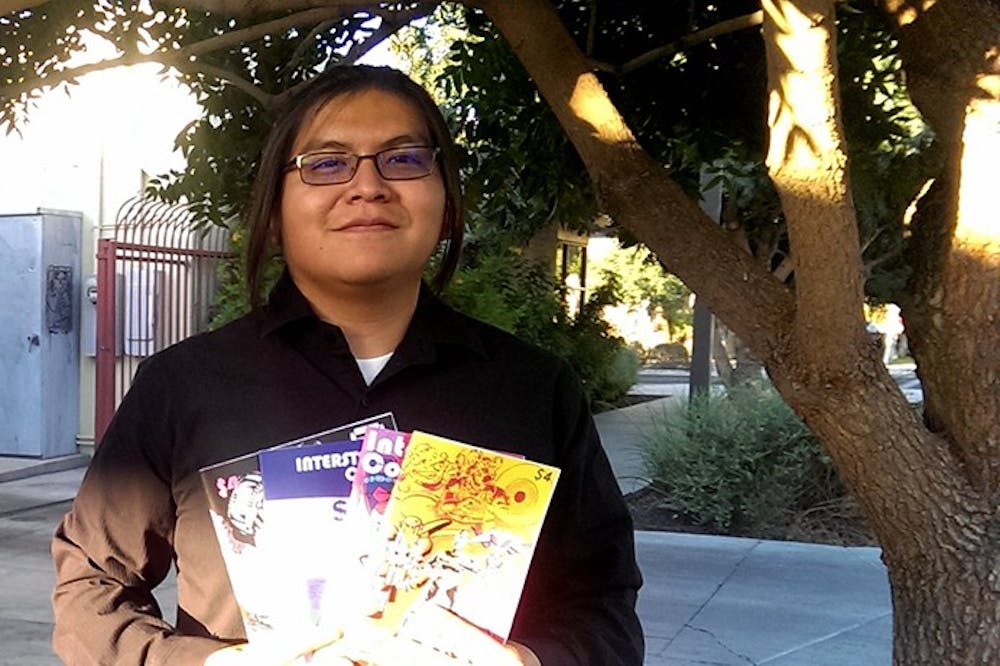 ASU student and comic book artist Damon Begay poses for a portrait with his series of comic books on Tuesday, June 14.&nbsp;
