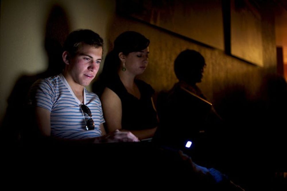 LIGHTS OUT: Jeffrey Ramirez studies by the light of his laptop in the hallway of the BAC building during a campus-wide power outage. Ramirez, a freshman marketing major, was reviewing his notes for his CIS 105 exam, which was cancelled shortly thereafter.