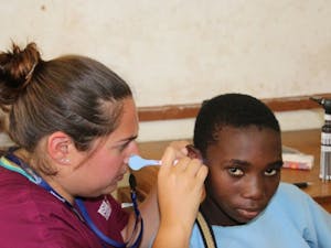 A Hearing for Humanity audiology student checks the ears of a young boy in Malawi during their annual trip.&nbsp;