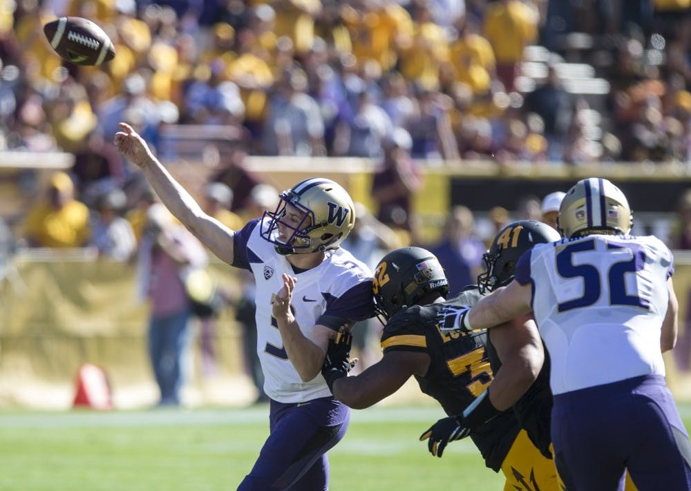 UW freshman quarterback Jake Browning gets off a pass before being tackled by redshirt senior linebacker Antonio Longino (32) in the first quarter of a game on Saturday, Nov. 14, 2015, at Sun Devil Stadium in Tempe, Ariz. UW leads ASU 17-0 at the half. 