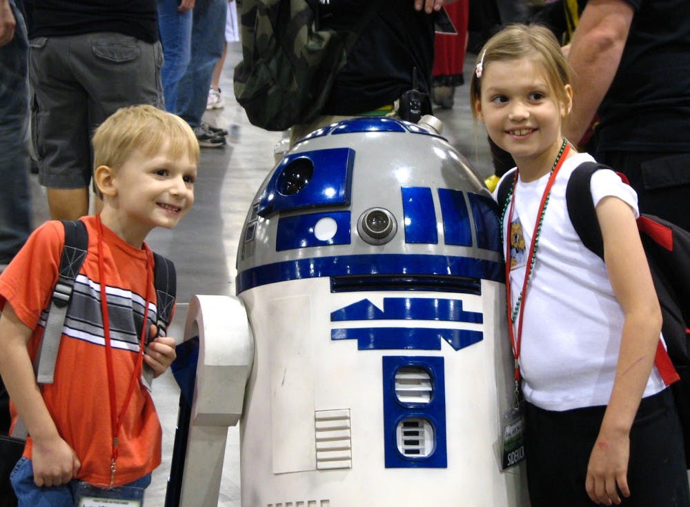 GEEK PARADISE: Children pose next to a replica of R2D2 at the Phoenix Comi-Con on Thursday night. Thousands of comic and sci-fi fans are expected to attend the annual convention this year that will include exhibits, appearances by film and television stars and hundreds of vendors. (Photo by Travis McKnight)