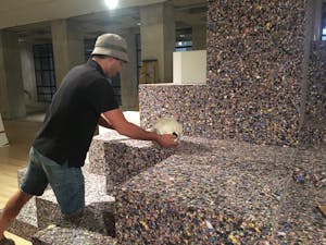 Artist Gabriel Rico places a piece for his new exhibition on a platform covered in carpet foam at the ASU Art Museum in Tempe, Arizona on Tuesday, May 20, 2017.
