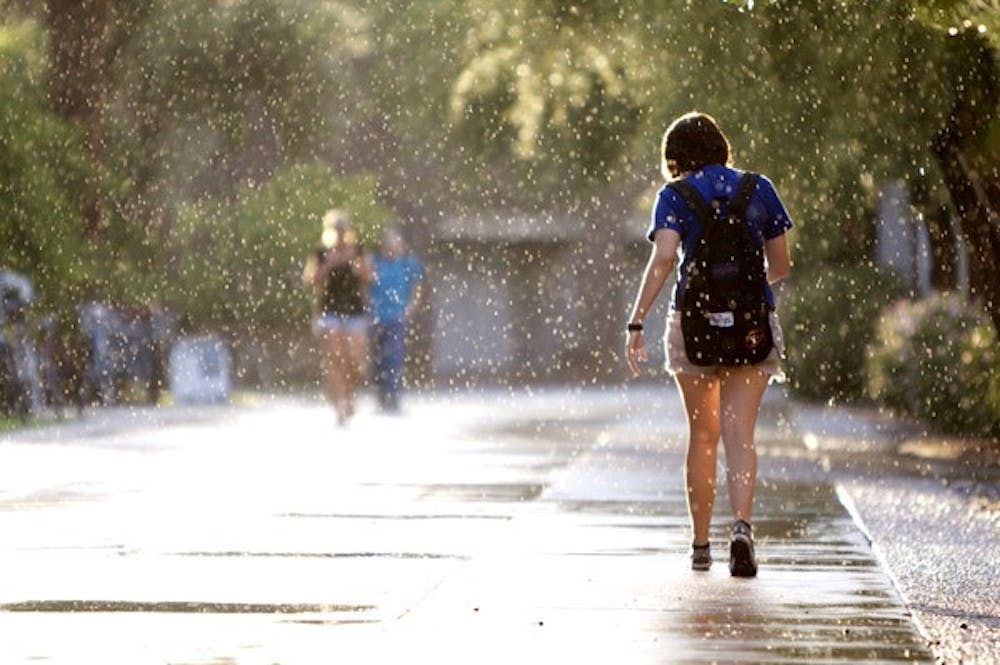 WALKING IN WATER: An ASU student on the Tempe campus walks through the sprinkling rain late Tuesday afternoon. (Photo By Scott Stuk)