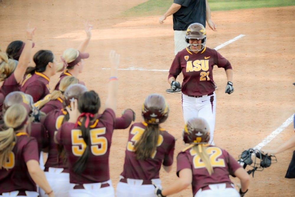 Senior first baseman Bethany Kemp is greeted by a joyous Sun Devil softball team at home plate ending the game against Oklahoma with a walk-off grand slam putting the final score at 8-4 on Sunday Feb. 15, 2015, at Farrington Stadium in Tempe. (J. Bauer-Leffler/The State Press)