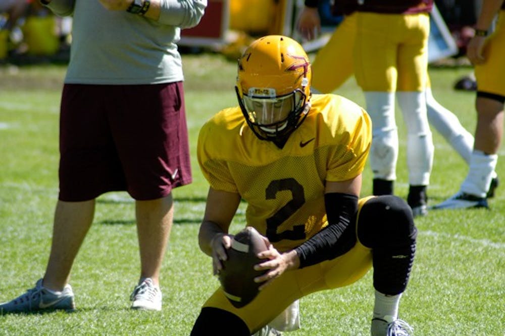 Redshirt junior Mike Bercovici places a football for a kicker at a practice on Aug. 16 at Camp Tontozona. (Photo by Fabian Ardaya)