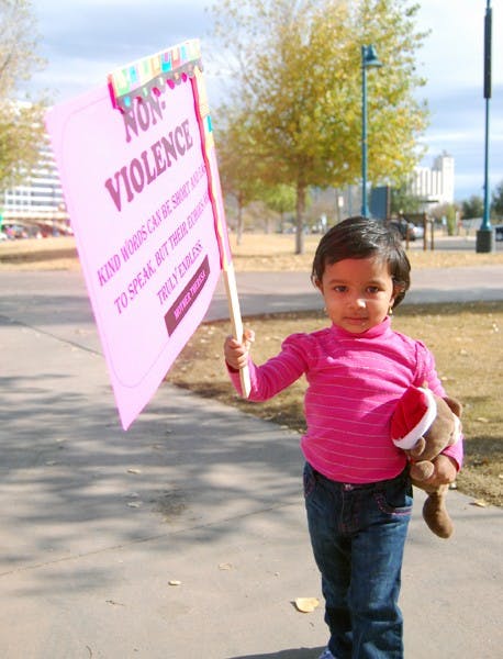 Two-year-old Vibha Moni Param holds her sign along with her teddy bear during the Walk for Values USA at Tempe Beach park Saturday afternoon. (Photo by Thania A. Betancourt)