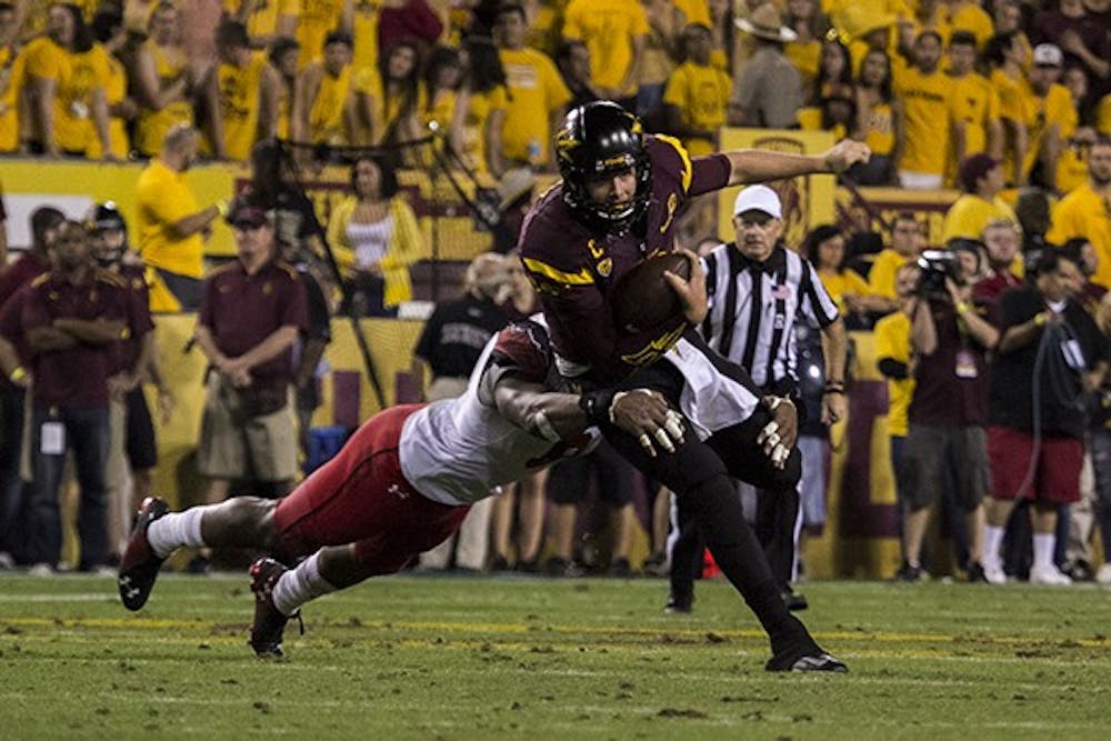 A Utah player attempts to tackle redshirt senior quarterback Taylor Kelly at a home game on Saturday, Nov. 1, 2014. ASU defeated Utah in overtime 19-16. (Photo by Alexis Macklin)