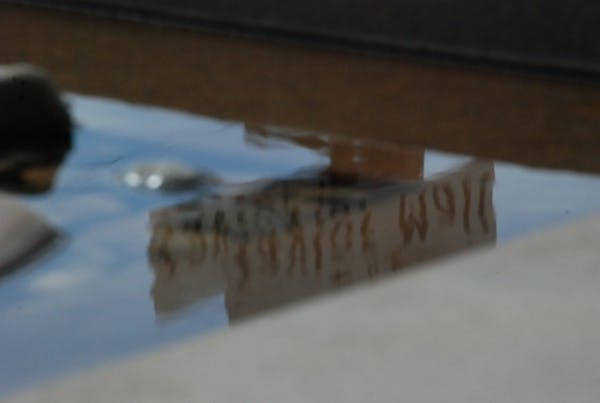 A Taylor Mall sign is reflected in the fountain in front of the Walter Cronkite School of Journalism and Mass Communication Tuesday afternoon. (Photo by W. Scot Grey)