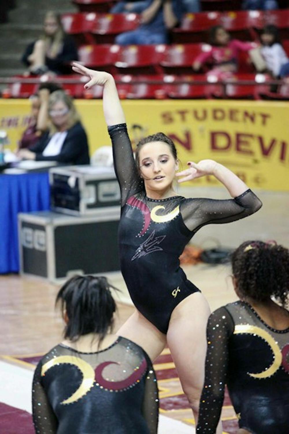 Sophomore Samantha Seaman is cheered on by her teammates during her floor routine in a meet against Cal on Jan. 20. The young Gym Devils continue to progress in the early stages of the season. (Photo by Beth Easterbrook)