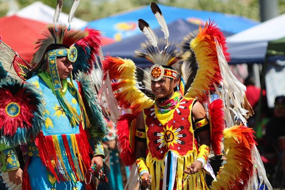 Two dancers have a laugh before the traditional dance circle commences at ASU’s Pow Wow event on the Tempe campus. The Pow Wow, which occurred adjacent to Sun Angel stadium, featured over a dozen tribes from across the country. (Photo by Dominic Valente)