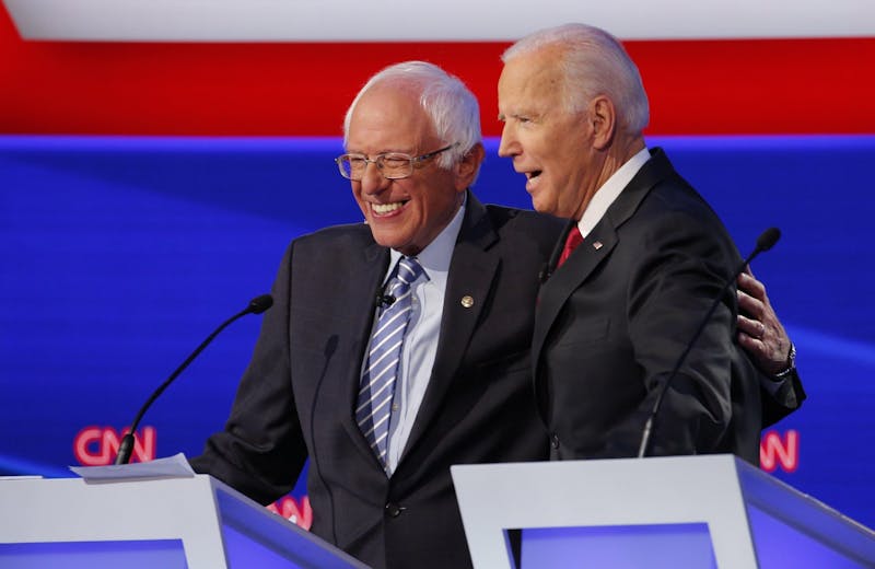 Sen. Bernie Sanders (I-Vt.) hugs former Vice President Joe Biden after joking that Biden called him Putin during a Democratic presidential debate on Tuesday, Oct. 15, 2019, at the Otterbein University Rike Center in Westerville, Ohio.