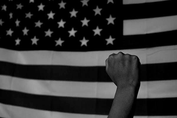 Photo illustration of a hand raised in the air, representing Tommie Smith and John Carlos' historic act in the 1968 summer olympics.