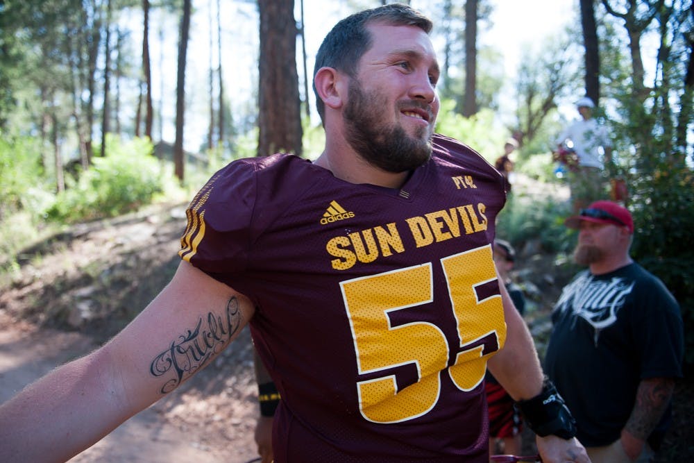 Redshirt senior offensive lineman Christian Westerman shakes a fan's hand while walking to the practice field during the last day of Camp Tontozona on Saturday, Aug. 15, 2015, in Payson, Arizona.