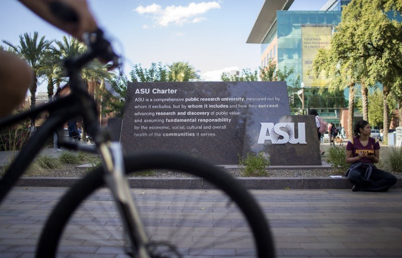 A student rides past the ASU Charter sign on the Tempe campus on Thursday, Sept. 14, 2017.