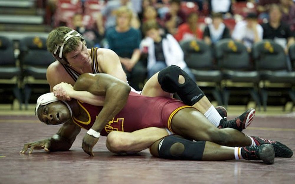 FIGHTING FOR POSITION: Sophomore Jake Meredith battles with Iowa State sophomore Jerome Ward during ASU’s 30-10 loss at Wells Fargo Arena in February. The Sun Devils finished the season 9-7 and had five wrestlers qualify for the NCAA Championships. (Photo by Michael Arellano)