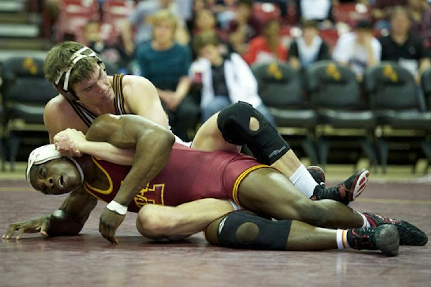 FIGHTING FOR POSITION: Sophomore Jake Meredith battles with Iowa State sophomore Jerome Ward during ASU’s 30-10 loss at Wells Fargo Arena in February. The Sun Devils finished the season 9-7 and had five wrestlers qualify for the NCAA Championships. (Photo by Michael Arellano)