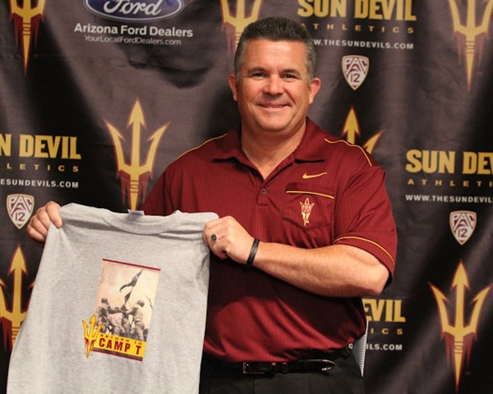 Football coach Todd Graham holds up a T-shirt at a press conference Thursday morning to announce the football team’s plan to return to Camp Tantozona this summer. (Photo courtesy of Steve Rodriguez)