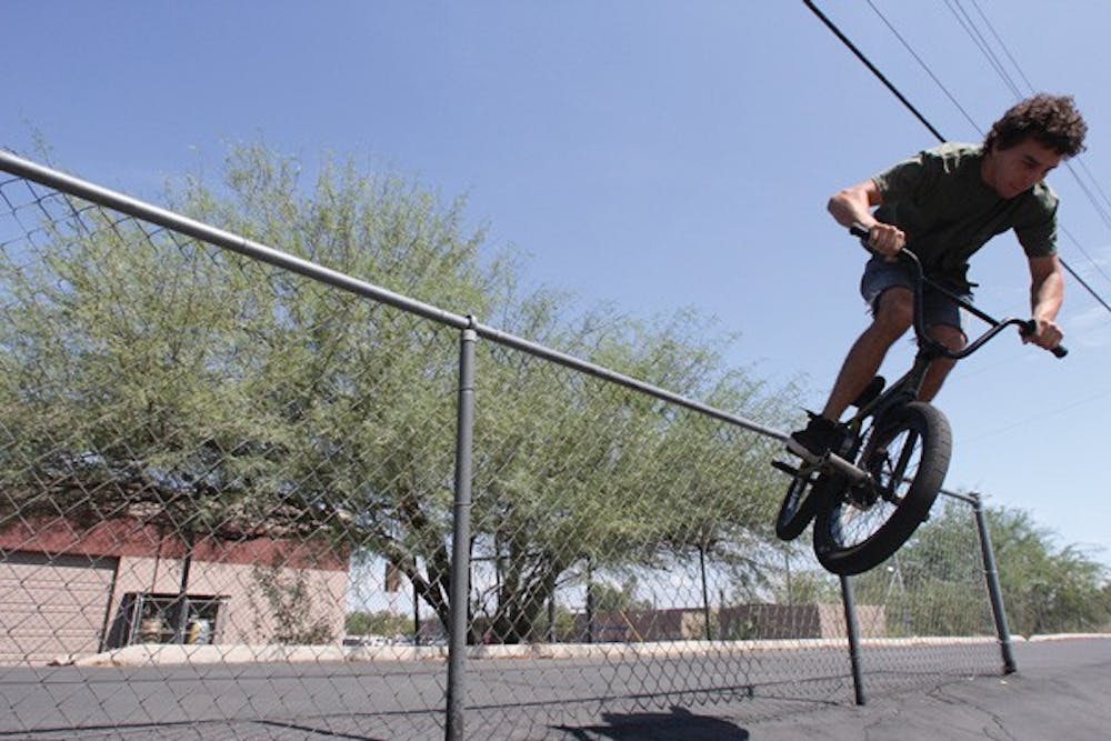 Drew Hosselton, 24, shows off his BMX moves in a parking lot near his home in Tempe.  (Photo by Ana Ramirez)